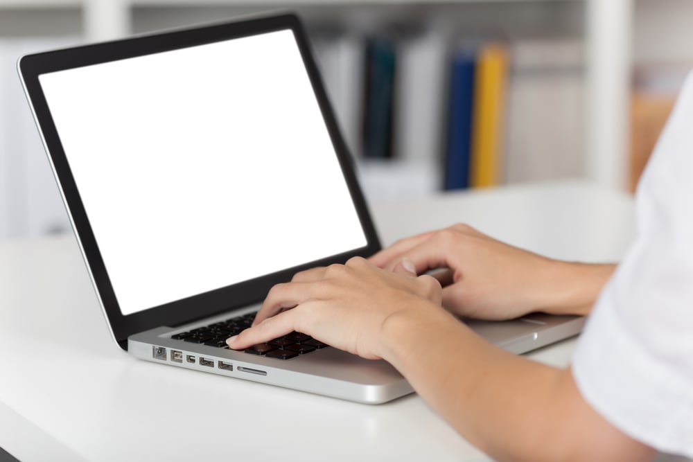 Rear view of business woman hands busy using laptop at office desk, with copyspace