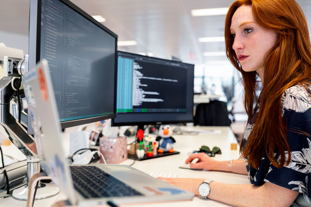 Software developer working on multiple monitors Software developer working on multiple monitors